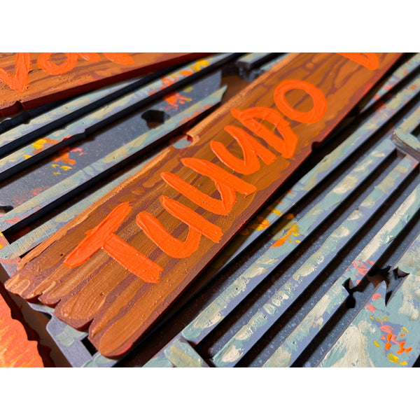 Detailed view of the original acrylic painting on layered wood "Vai correr tudo bem" by Mário Belém, highlighting the vibrant hand-painted typography, the intricate graphic elements, and the distinct relief of the overlapping wood layers.